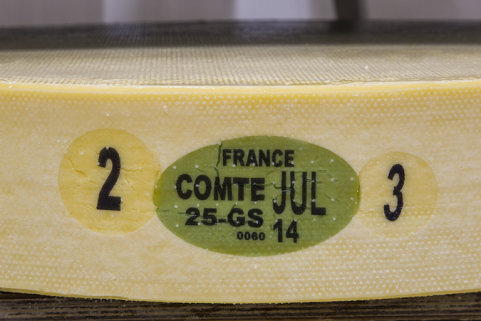 Fabrication : plaques d'identification d'une meule de comté. La plaque verte indique l'origine France, l'appellation Comté, le mois et l'année de fabrication, le code du département et le code de la fromagerie. Elle est encadrée à gauche par le jour… © Région Bourgogne-Franche-Comté, Inventaire du patrimoine