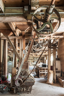 Rez-de-chaussée surélevé. Broyeur à cylindres Lacroix et le système de transmission. © Région Bourgogne-Franche-Comté, Inventaire du patrimoine