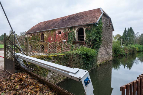 Le bâtiment à fonction agricole depuis le dégrilloir du bief d'amenée. © Région Bourgogne-Franche-Comté, Inventaire du patrimoine