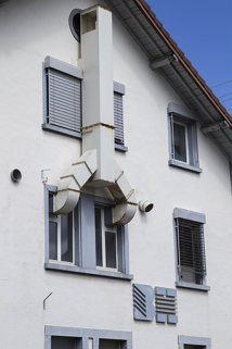 Usine, 1er corps de bâtiment : fenêtres horlogères, installation de ventilation et logotype, sur la façade latérale gauche. © Région Bourgogne-Franche-Comté, Inventaire du patrimoine Usine, 1er corps de bâtiment : fenêtres horlogères, installation de ventilation et logotype, sur la façade latérale gauche. © Région Bourgogne-Franche-Comté, Inventaire du patrimoine