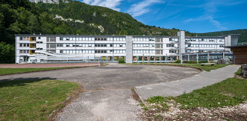 Vue d'ensemble de l'internat depuis les terrains de sport, à droite le passage couvert vers l'externat. © Région Bourgogne-Franche-Comté, Inventaire du patrimoine