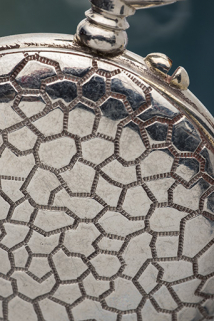 Boîte de montre de gousset en métal chromé : détail du décor imitant le cuir de corcodile. © Région Bourgogne-Franche-Comté, Inventaire du patrimoine