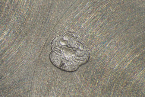 Poinçon de garantie insculpé sur un fond de boîte : un crabe (garantie menus ouvrages 2e titre départements depuis 1838), avec le différent de Besançon entre les pattes inférieures. © Région Bourgogne-Franche-Comté, Inventaire du patrimoine