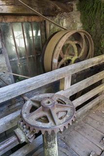 Au premier plan, système de contrôle de l'admission d'eau de la turbine hydraulique. Au second plan, poulies de renvoi vers les ateliers de forge et de mécanique. © Région Bourgogne-Franche-Comté, Inventaire du patrimoine