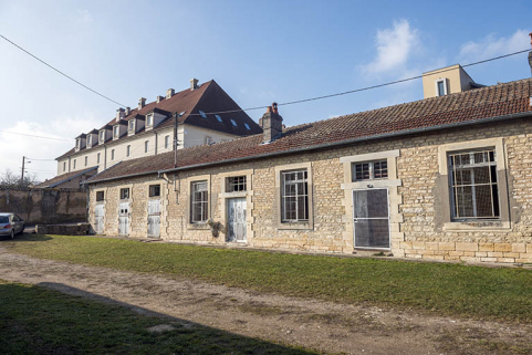 Cour "au bas de la caserne," façade sud-est de la barre de logements et écuries ; au second plan le bâtiment de cantine et internat de filles.  © Région Bourgogne-Franche-Comté, Inventaire du patrimoine