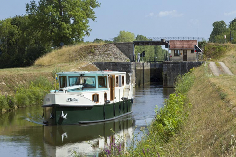 Bateau de plaisance et l'écluse en arrière-plan. © Région Bourgogne-Franche-Comté, Inventaire du patrimoine Bateau de plaisance et l'écluse en arrière-plan. © Région Bourgogne-Franche-Comté, Inventaire du patrimoine