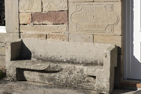 Détail de l'inscription de fondation (1845) et du banc devant la façade antérieure de la maison, 14 rue Principale.  © Région Bourgogne-Franche-Comté, Inventaire du patrimoine