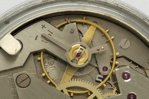 4e montre, mouvement Parrenin HP 40 : numéro de modèle Lip (R 167) gravé près du pont de balancier. Mal effacée, la pointe supérieure du logotype Parrenin est visible à gauche, près d'une vis du balancier. © Région Bourgogne-Franche-Comté, Inventaire du patrimoine