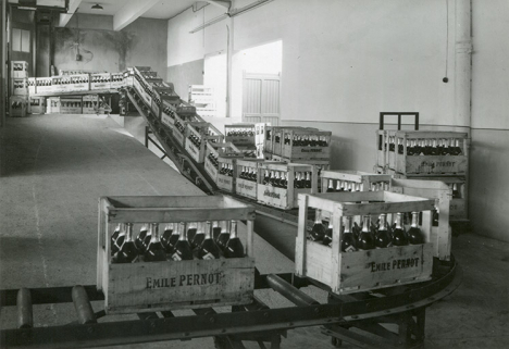 Caisses de bouteilles sur convoyeur à rouleaux, photogr., s.d. [milieu 20e siècle]. © Région Bourgogne-Franche-Comté, Inventaire du patrimoine