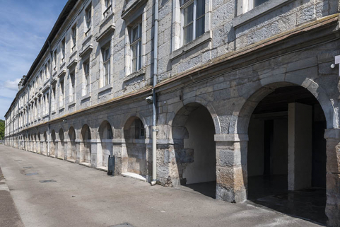 Façade postérieure, vue en enfilade de trois quarts droite. A droite, les baies donnant accès au passage couvert. © Région Bourgogne-Franche-Comté, Inventaire du patrimoine Façade postérieure, vue en enfilade de trois quarts droite. A droite, les baies donnant accès au passage couvert. © Région Bourgogne-Franche-Comté, Inventaire du patrimoine
