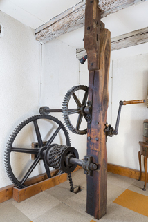 Premier étage. Système de levage (par manivelle et chaîne) de la roue suspendue (aval). © Région Bourgogne-Franche-Comté, Inventaire du patrimoine