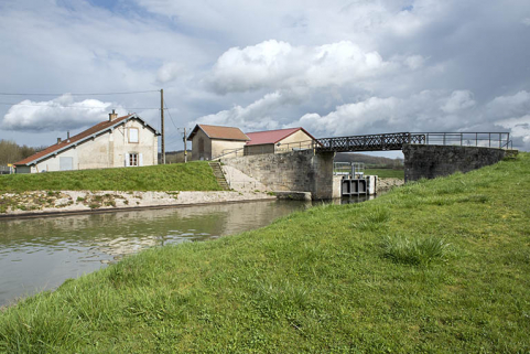 La porte de garde, la maison du garde, le hangar (Voies navigables de France), la passerelle vus de la rive gauche en aval.  © Région Bourgogne-Franche-Comté, Inventaire du patrimoine La porte de garde, la maison du garde, le hangar (Voies navigables de France), la passerelle vus de la rive gauche en aval.  © Région Bourgogne-Franche-Comté, Inventaire du patrimoine