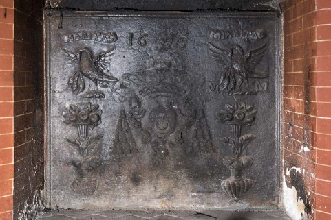 Rez-de-chaussée : première pièce à gauche de l'entrée. Plaque de cheminée. "Charitas 1699". © Région Bourgogne-Franche-Comté, Inventaire du patrimoine