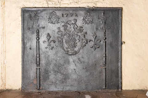 A l'étage : seconde pièce à gauche depuis l'escalier. (angle sud) Plaque de cheminée. (1772) © Région Bourgogne-Franche-Comté, Inventaire du patrimoine