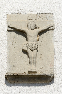 Détail du bas relief figurant au-dessus de la porte de grange : un Christ en croix. © Région Bourgogne-Franche-Comté, Inventaire du patrimoine