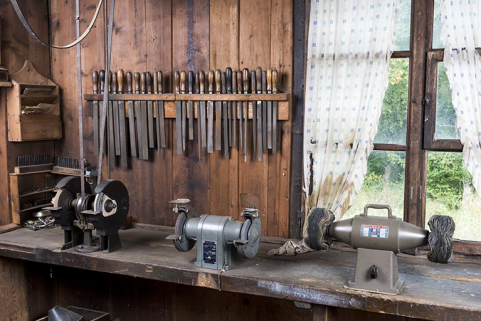 Tourets à polir fixés sur l'établi derrière la fenêtre simple. © Région Bourgogne-Franche-Comté, Inventaire du patrimoine