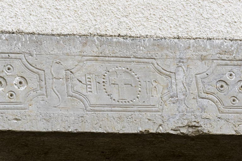Logement : croix, instruments de la Passion et serpents, sur un linteau orné (façade postérieure). © Région Bourgogne-Franche-Comté, Inventaire du patrimoine Logement : croix, instruments de la Passion et serpents, sur un linteau orné (façade postérieure). © Région Bourgogne-Franche-Comté, Inventaire du patrimoine