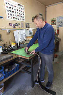 Intérieur de l'atelier de bourrellerie : découpe d'une sangle de cuir. © Région Bourgogne-Franche-Comté, Inventaire du patrimoine