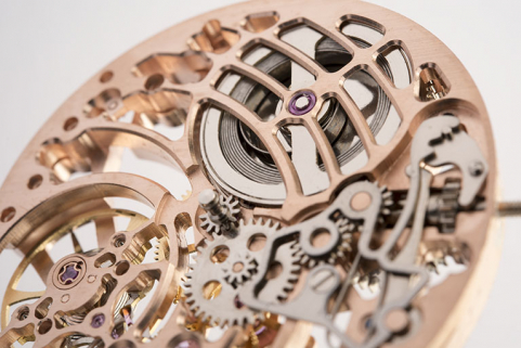 Mouvement rose, détail côté cadran : amortisseur de chocs (à gauche), tirette et pont de barillet (avec ressort moteur). © Région Bourgogne-Franche-Comté, Inventaire du patrimoine