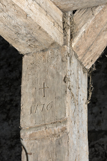 Détail de date (1776) et de croix sculptée sur un poteau de la charpente de la grange.  © Région Bourgogne-Franche-Comté, Inventaire du patrimoine Détail de date (1776) et de croix sculptée sur un poteau de la charpente de la grange.  © Région Bourgogne-Franche-Comté, Inventaire du patrimoine