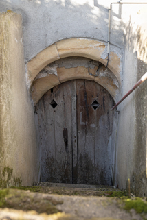 Entrée de cellier à arc en plein cintre, à ressauts formé de deux rouleaux.  © Région Bourgogne-Franche-Comté, Inventaire du patrimoine Entrée de cellier à arc en plein cintre, à ressauts formé de deux rouleaux.  © Région Bourgogne-Franche-Comté, Inventaire du patrimoine