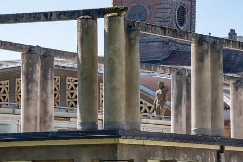Situation de la statue, vue à travers la pergola de la terrasse de l'aile ouest de la piscine. © Région Bourgogne-Franche-Comté, Inventaire du patrimoine Situation de la statue, vue à travers la pergola de la terrasse de l'aile ouest de la piscine. © Région Bourgogne-Franche-Comté, Inventaire du patrimoine