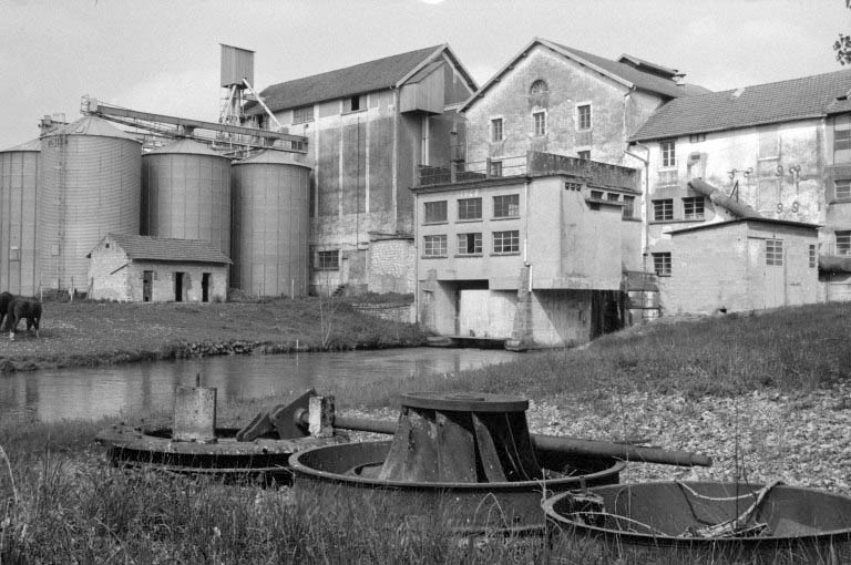 Bâtiment d'eau (J), ateliers de fabrication (L, M) et silos (C, D) vus du sud-ouest. Eléments d'une turbine Singrun au premier plan. © Région Bourgogne-Franche-Comté, Inventaire du patrimoine