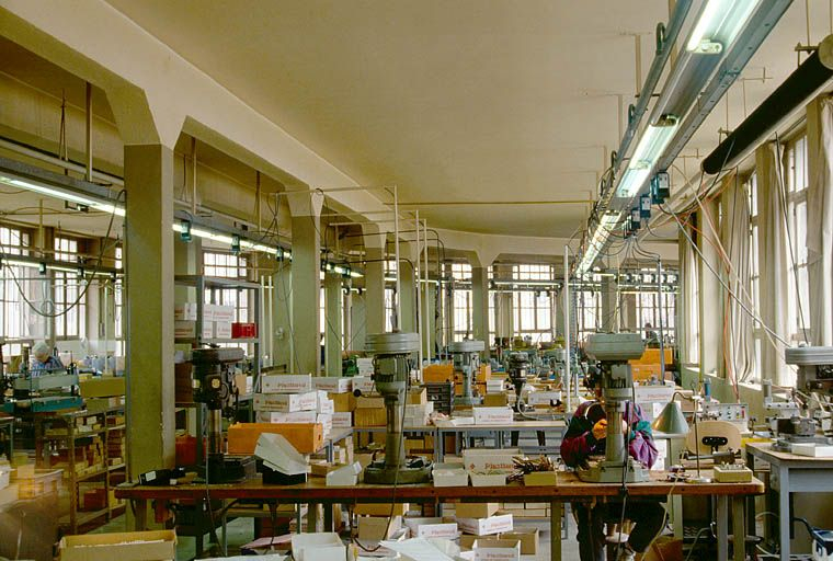 Ateliers de fabrication (1928-1929) : vue d'ensemble du rez-de-chaussée, depuis l'entrée. © Région Bourgogne-Franche-Comté, Inventaire du patrimoine Ateliers de fabrication (1928-1929) : vue d'ensemble du rez-de-chaussée, depuis l'entrée. © Région Bourgogne-Franche-Comté, Inventaire du patrimoine