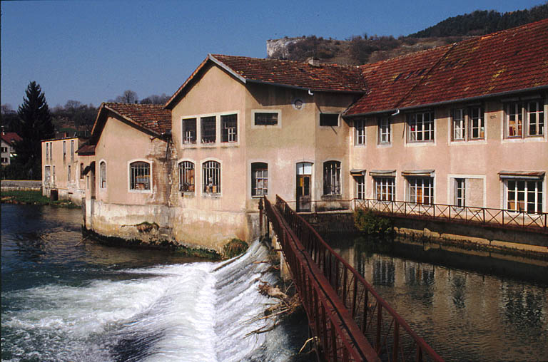 Bâtiment d'eau et atelier de fabrication du moulin depuis la passerelle du barrage. © Région Bourgogne-Franche-Comté, Inventaire du patrimoine Bâtiment d'eau et atelier de fabrication du moulin depuis la passerelle du barrage. © Région Bourgogne-Franche-Comté, Inventaire du patrimoine