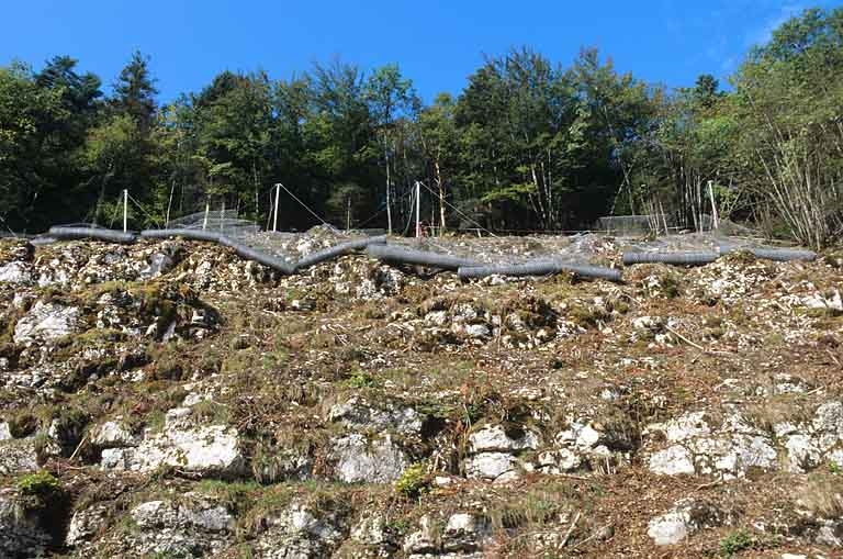 Sécurisation de paroi rocheuse à Syam : rouleaux de filet de protection en attente de déroulage. © Région Bourgogne-Franche-Comté, Inventaire du patrimoine Sécurisation de paroi rocheuse à Syam : rouleaux de filet de protection en attente de déroulage. © Région Bourgogne-Franche-Comté, Inventaire du patrimoine