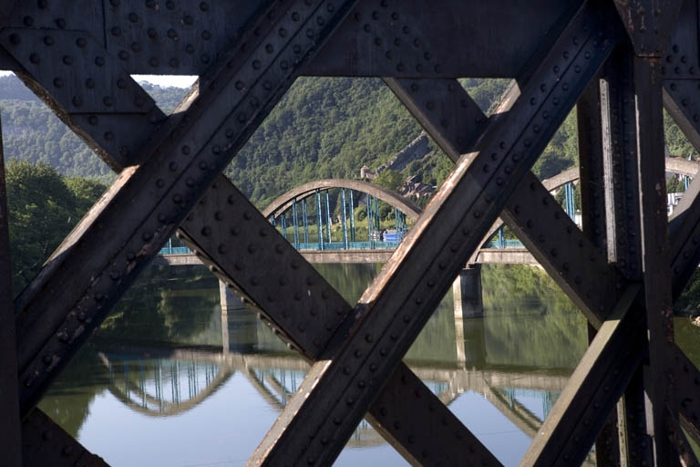Vue d'ensemble du pont au travers du treillis métallique du pont-rail de la ligne de Morteau. © Région Bourgogne-Franche-Comté, Inventaire du patrimoine Vue d'ensemble du pont au travers du treillis métallique du pont-rail de la ligne de Morteau. © Région Bourgogne-Franche-Comté, Inventaire du patrimoine