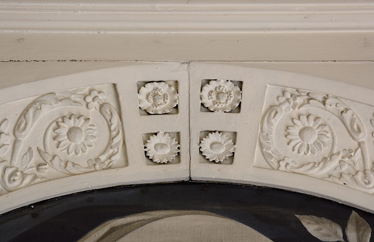 Intérieur, premier étage : détail du décor sculpté, partie supérieure d'un dessus de porte de la bibliothèque, vue rapprochée. © Région Bourgogne-Franche-Comté, Inventaire du Patrimoine