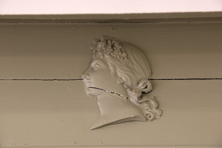 Détail d'une tête de femme de profil ornant les lambris d'une pièce située au premier étage. © Région Bourgogne-Franche-Comté, Inventaire du Patrimoine