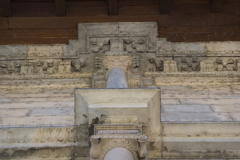 Façade principale : détail de deux chapiteaux ionique et composite, en contre-plongée. © Région Bourgogne-Franche-Comté, Inventaire du Patrimoine Façade principale : détail de deux chapiteaux ionique et composite, en contre-plongée. © Région Bourgogne-Franche-Comté, Inventaire du Patrimoine