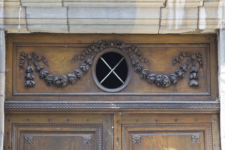 Façade antérieure, partie gauche, portail d'entrée : détail du décor de la partie supérieure. © Région Bourgogne-Franche-Comté, Inventaire du Patrimoine