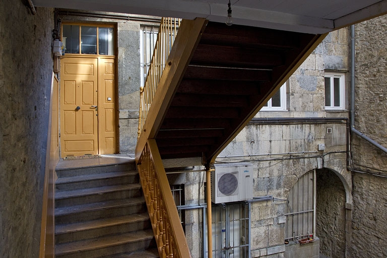 Logis principal : vue de l'intérieur de l'escalier à cage ouverte et de la porte d'entrée de l'appartement du premier étage. © Région Bourgogne-Franche-Comté, Inventaire du Patrimoine