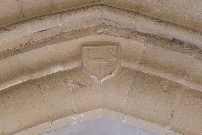 Arc brisé à la jonction de la nef et du transept : écu portant les initials I R et un marteau de sculpteur. © Région Bourgogne-Franche-Comté, Inventaire du patrimoine Arc brisé à la jonction de la nef et du transept : écu portant les initials I R et un marteau de sculpteur. © Région Bourgogne-Franche-Comté, Inventaire du patrimoine