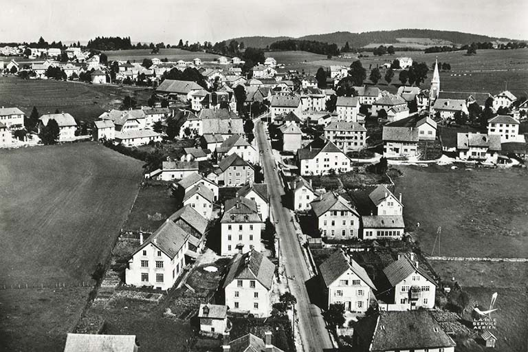 En avion au-dessus de... 1. Charquemont (Doubs). La Grande Rue [le bas du village vu du sud], 3e quart 20e siècle. Les bâtiments sont au premier plan à droite. © Région Bourgogne-Franche-Comté, Inventaire du patrimoine
