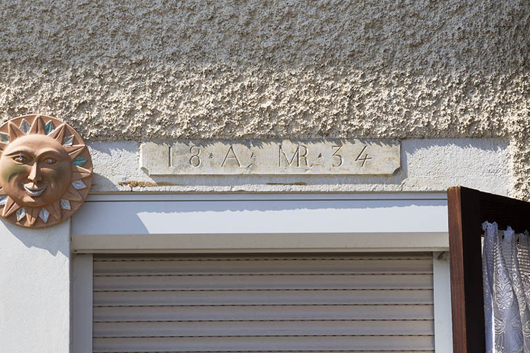 Initiales et chronogramme sur le linteau de l'entrée. © Région Bourgogne-Franche-Comté, Inventaire du patrimoine
