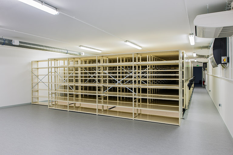 Entrepôt, 1er étage (partie surélevée) : salle d'archivage, depuis le fond de la pièce. © Région Bourgogne-Franche-Comté, Inventaire du patrimoine Entrepôt, 1er étage (partie surélevée) : salle d'archivage, depuis le fond de la pièce. © Région Bourgogne-Franche-Comté, Inventaire du patrimoine