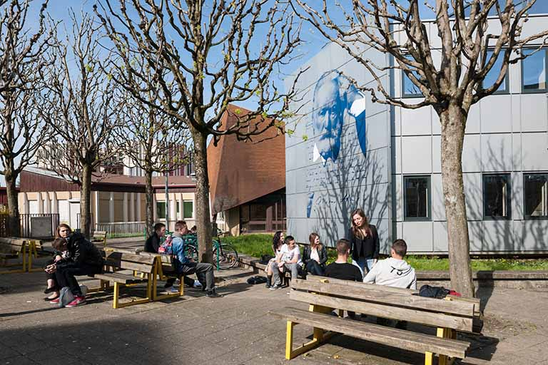 Vue de la place devant le lycée, la façade sud-est décorée à l'effigie de Victor Hugo. © Région Bourgogne-Franche-Comté, Inventaire du patrimoine