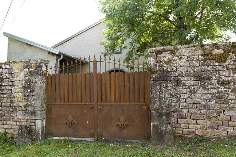 Mur d'enclos sud avec des fleurs de lys sur la grille. © Région Bourgogne-Franche-Comté, Inventaire du patrimoine