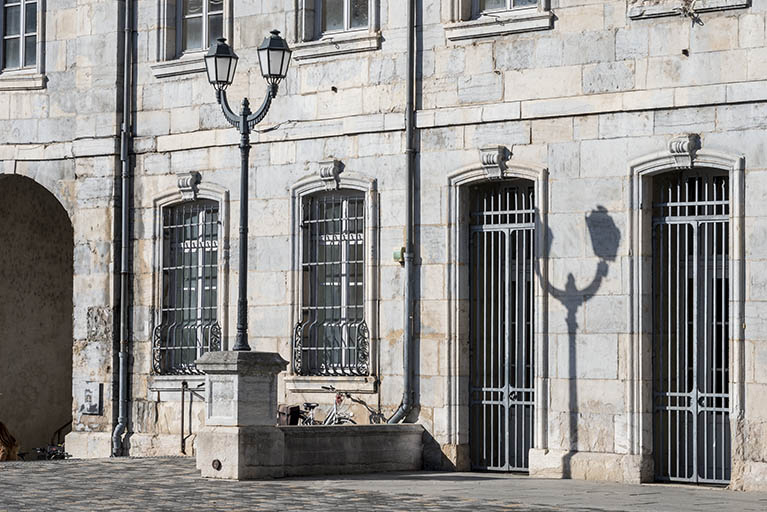 Façade antérieure : portes et fenêtres du rez-de-chaussée, à gauche de l'avant-corps, et lampadaire. © Région Bourgogne-Franche-Comté, Inventaire du patrimoine Façade antérieure : portes et fenêtres du rez-de-chaussée, à gauche de l'avant-corps, et lampadaire. © Région Bourgogne-Franche-Comté, Inventaire du patrimoine