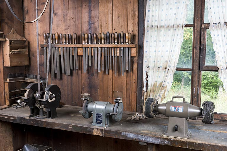 Tourets à polir fixés sur l'établi derrière la fenêtre simple. © Région Bourgogne-Franche-Comté, Inventaire du patrimoine