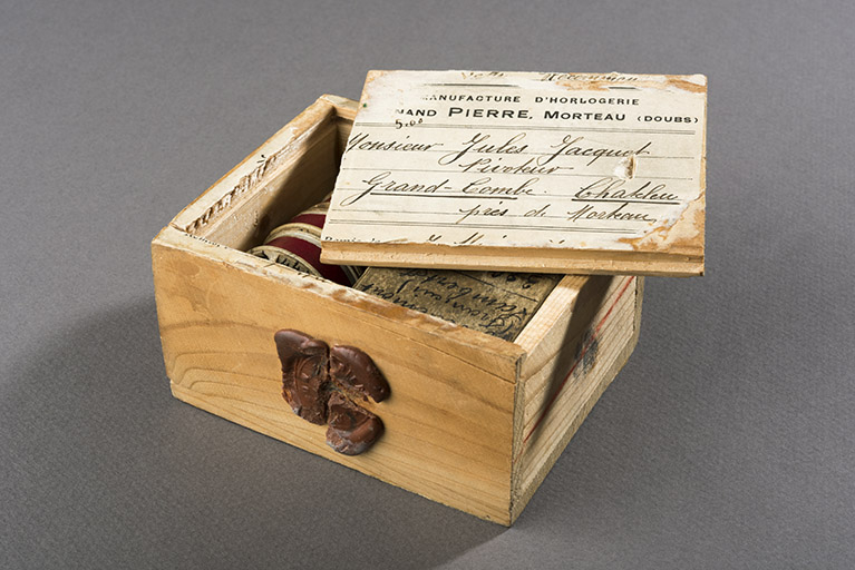 Boîte pour l'expédition des pièces d'horlogerie par la poste (collection Jean-Claude Vuez, Villers-le-Lac). Elle est adressée par la fabrique de montres de Fernand Pierre, à Morteau, au pivoteur Jules Jacquet-Pierroulet, à Grand'Combe-Châteleu. © Région Bourgogne-Franche-Comté, Inventaire du patrimoine Boîte pour l'expédition des pièces d'horlogerie par la poste (collection Jean-Claude Vuez, Villers-le-Lac). Elle est adressée par la fabrique de montres de Fernand Pierre, à Morteau, au pivoteur Jules Jacquet-Pierroulet, à Grand'Combe-Châteleu. © Région Bourgogne-Franche-Comté, Inventaire du patrimoine