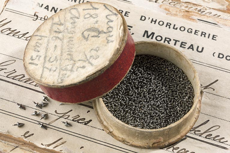 Boîte de tiges d'ancre destinées aux Ets Anguenot Frères, de Villers-le-Lac (collection Jean-Claude Vuez, Villers-le-Lac). Le couvercle porte l'inscription : "tiges / 18'' G 22/12 / Anguenot Frères / 116-57 / pas 51". © Région Bourgogne-Franche-Comté, Inventaire du patrimoine Boîte de tiges d'ancre destinées aux Ets Anguenot Frères, de Villers-le-Lac (collection Jean-Claude Vuez, Villers-le-Lac). Le couvercle porte l'inscription : "tiges / 18'' G 22/12 / Anguenot Frères / 116-57 / pas 51". © Région Bourgogne-Franche-Comté, Inventaire du patrimoine