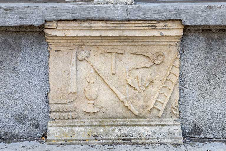 Bas-relief : les instruments de la Passion, façade antérieure de l'ancienne cure. © Région Bourgogne-Franche-Comté, Inventaire du patrimoine Bas-relief : les instruments de la Passion, façade antérieure de l'ancienne cure. © Région Bourgogne-Franche-Comté, Inventaire du patrimoine