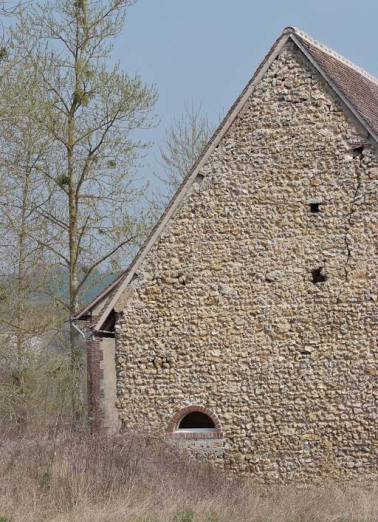 Mur-pignon du bâtiment à gauche en entrant, appareil en silex. © Région Bourgogne-Franche-Comté, Inventaire du patrimoine