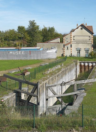 De gauche à droite, la péniche-salle d'exposition du Musée du Canal, la boulangerie de la cité Perrusson dans l'axe de l'ancien tracé du canal. © Région Bourgogne-Franche-Comté, Inventaire du patrimoine