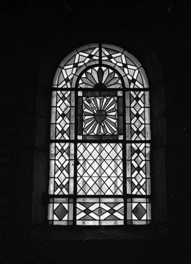 Baie n° 4 réalisée au 19e siècle : vitrerie géométrique colorée avec le coeur du Christ au registre supérieur, un complément en verre du 20e siècle. © Région Bourgogne-Franche-Comté, Inventaire du patrimoine
